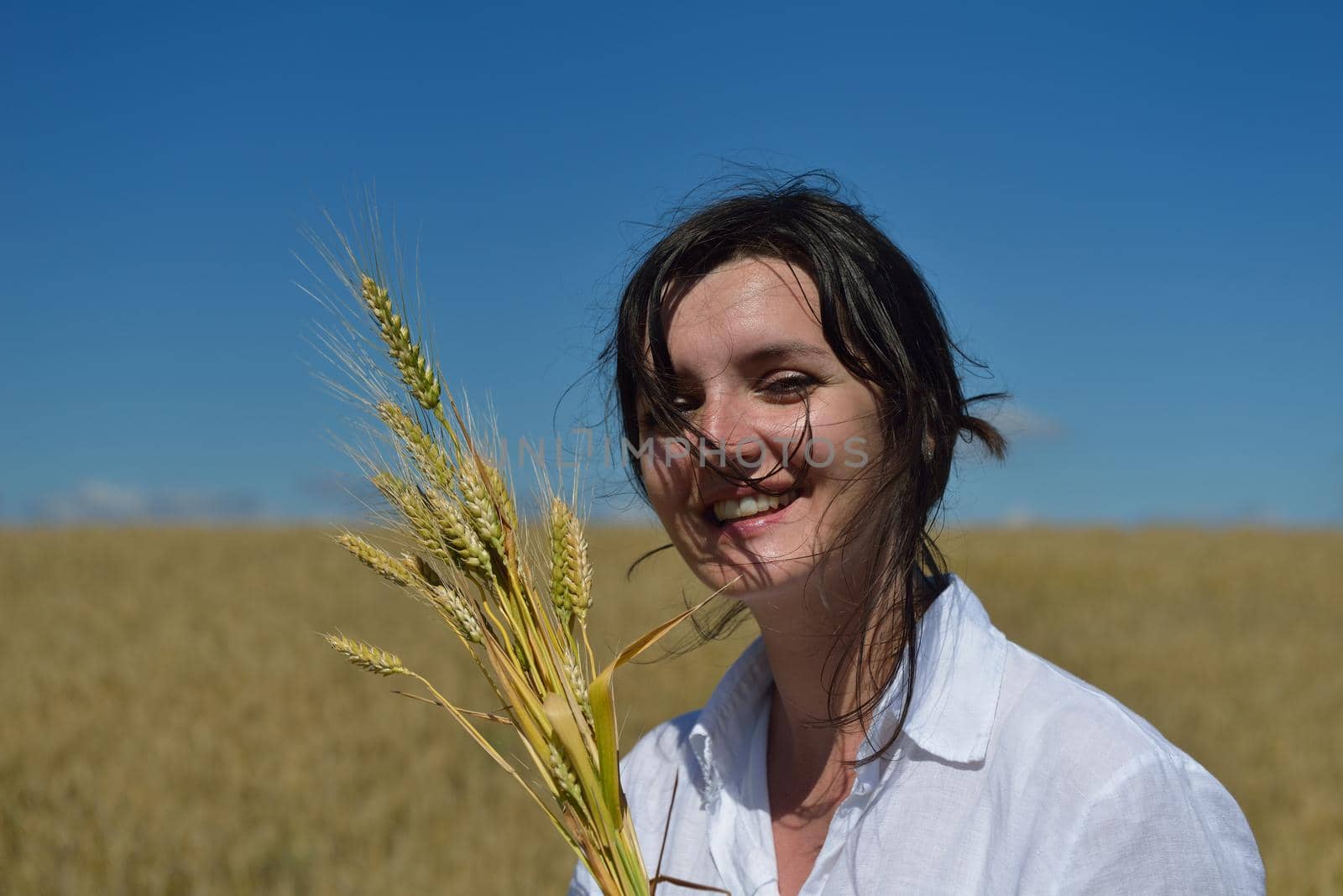 young woman in wheat field at summer by dotshock