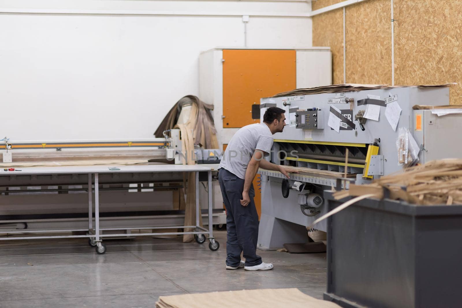 Young worker works in a factory for the production of wooden furniture