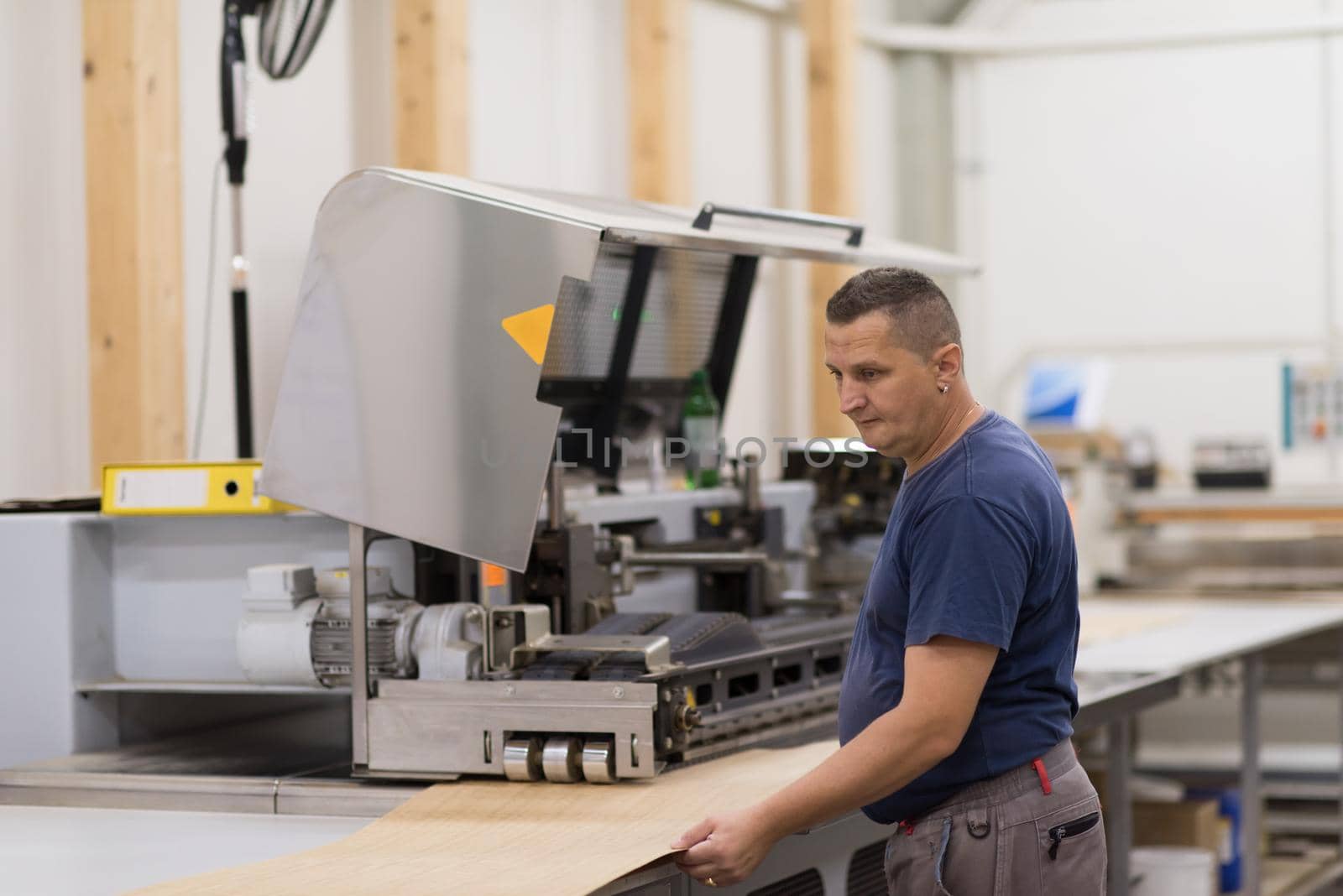 worker in a factory of wooden furniture by dotshock