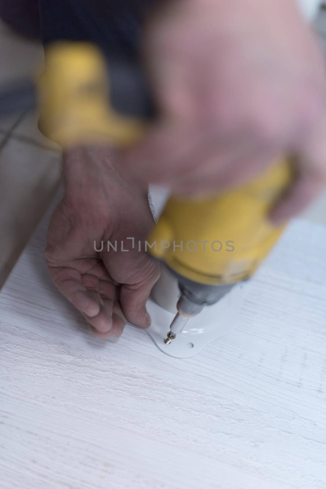 repairman working with drilling machine and assambling  furniture