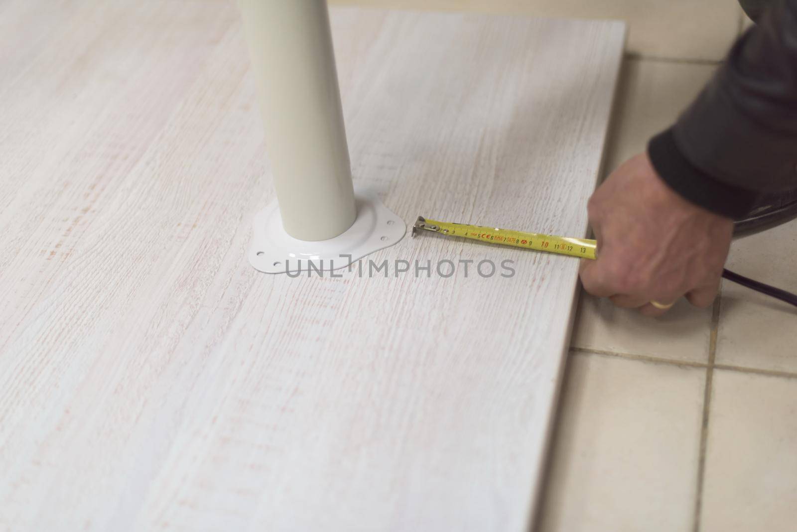 carpenter worker measuring distance for drilling holes in new furniture