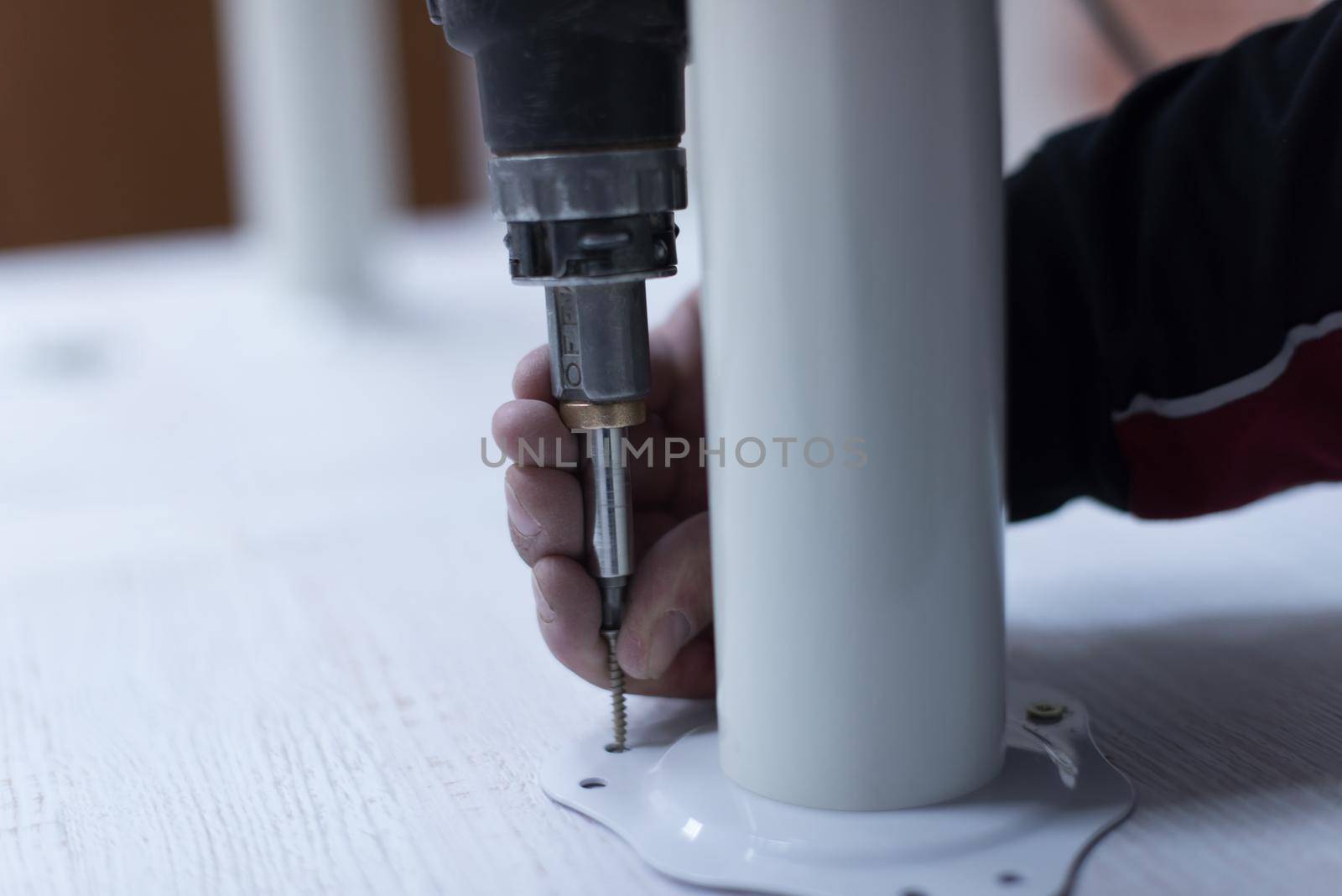 repairman working with drilling machine and assambling  furniture