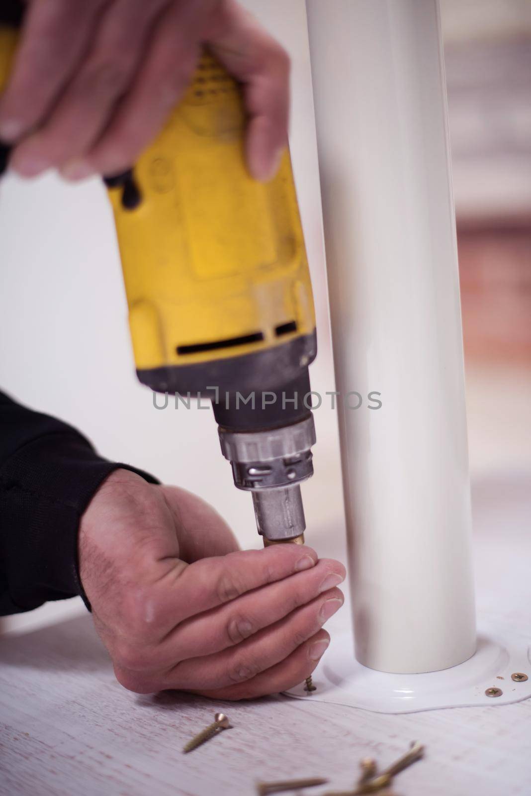 repairman working with drilling machine and assambling  furniture