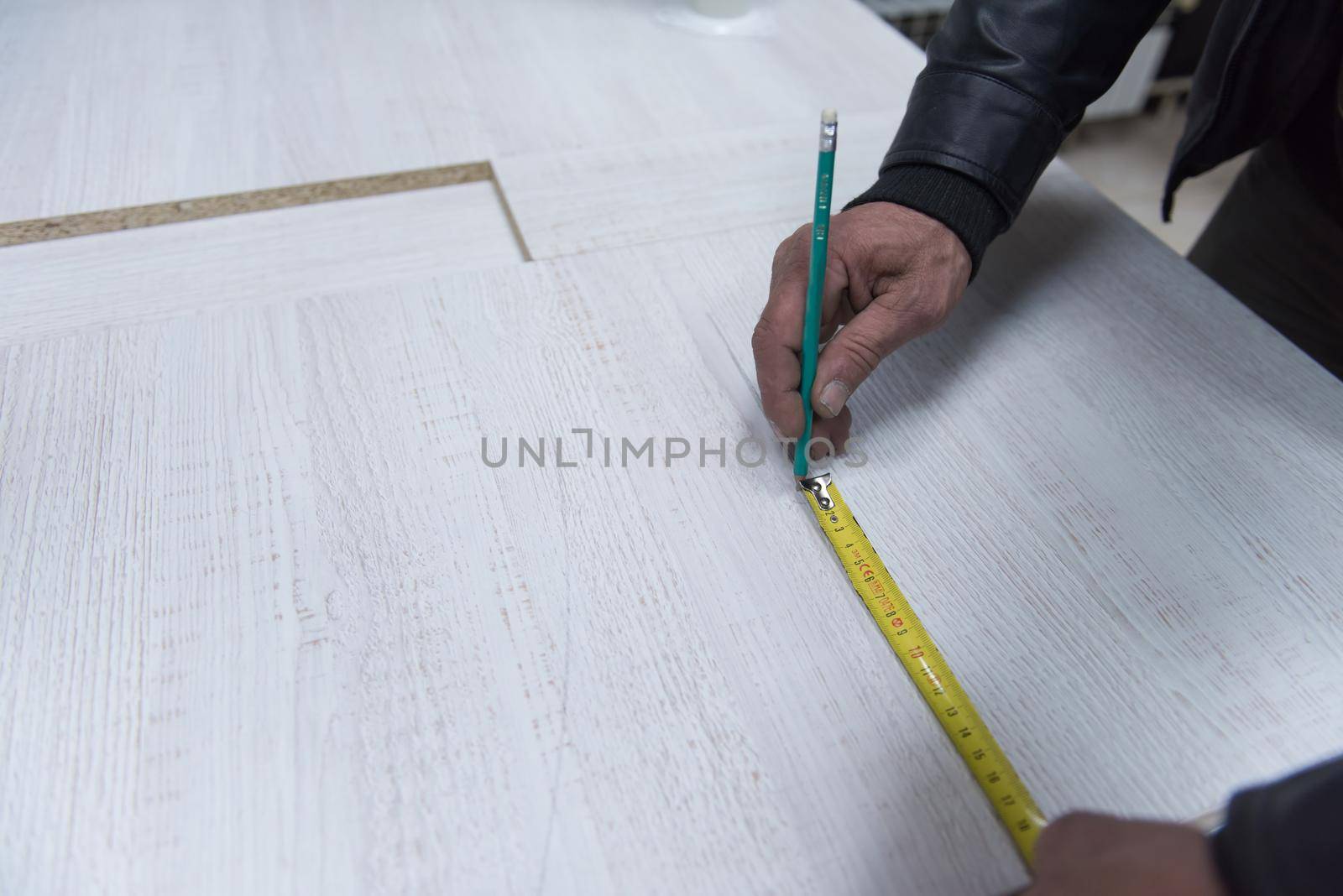 carpenter worker measuring distance for drilling holes in new furniture