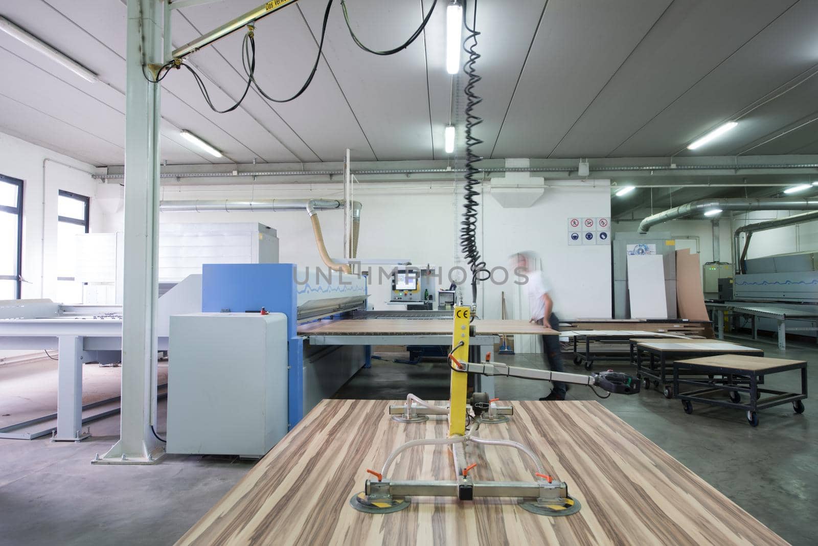 Young worker works in a factory for the production of wooden furniture