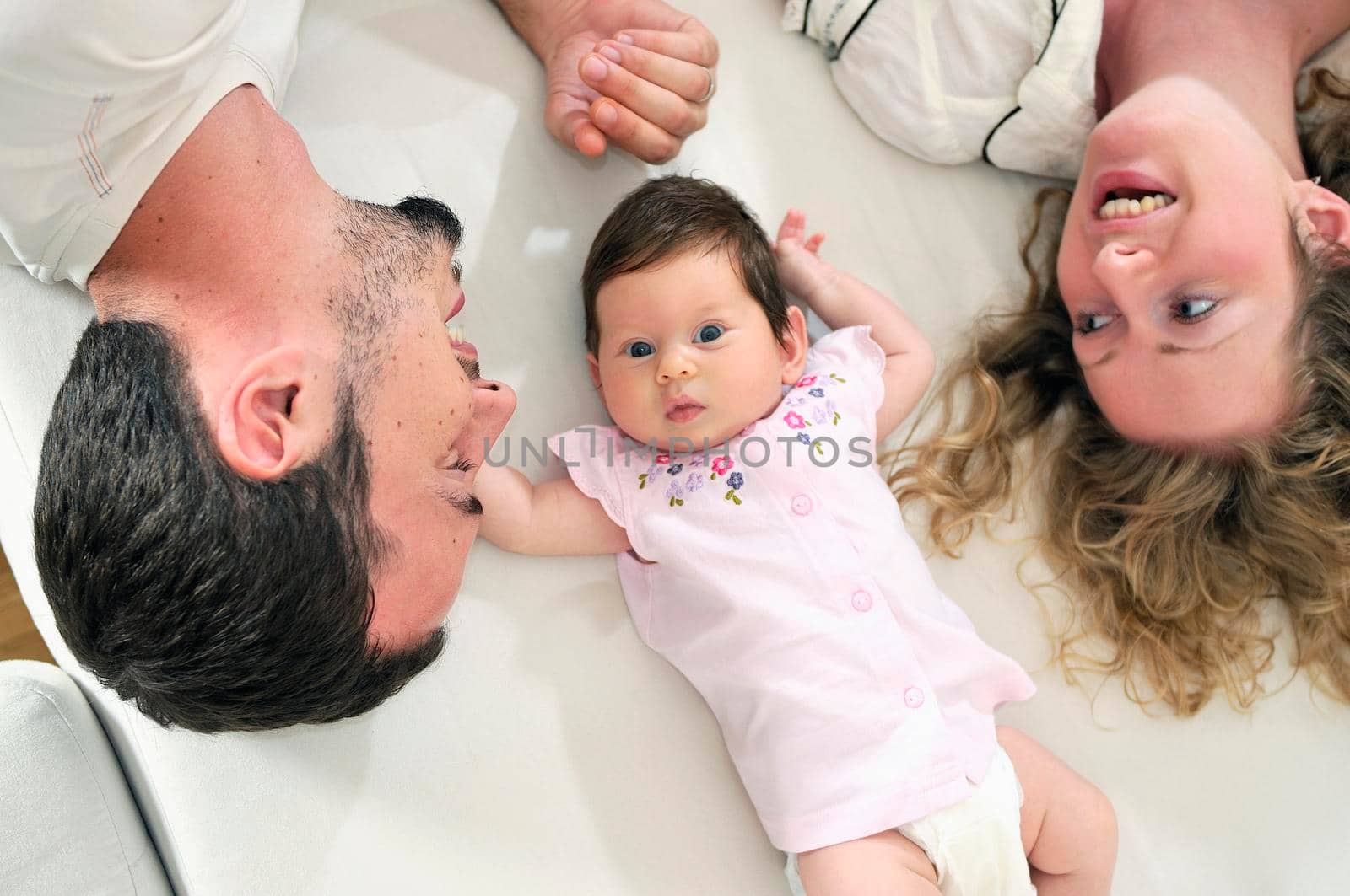 indoor portrait with happy young family and  cute little babby