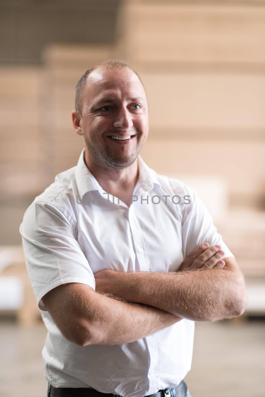 Portrait of an independent designer in his furniture manufacturing workshop, looking relaxed and confident
