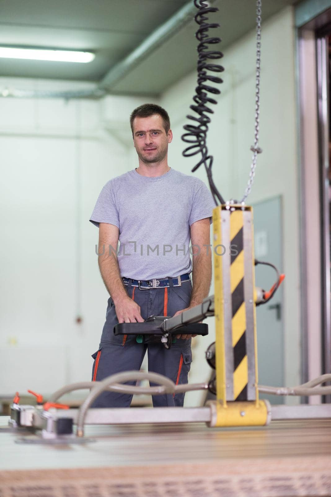 Young worker works in a factory for the production of wooden furniture