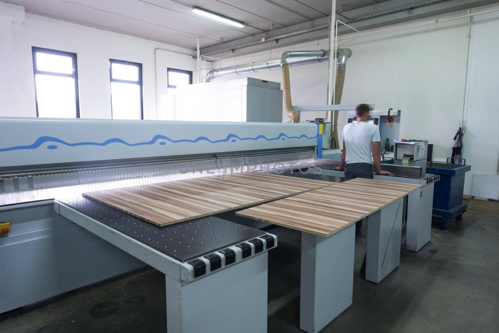 Young worker works in a factory for the production of wooden furniture