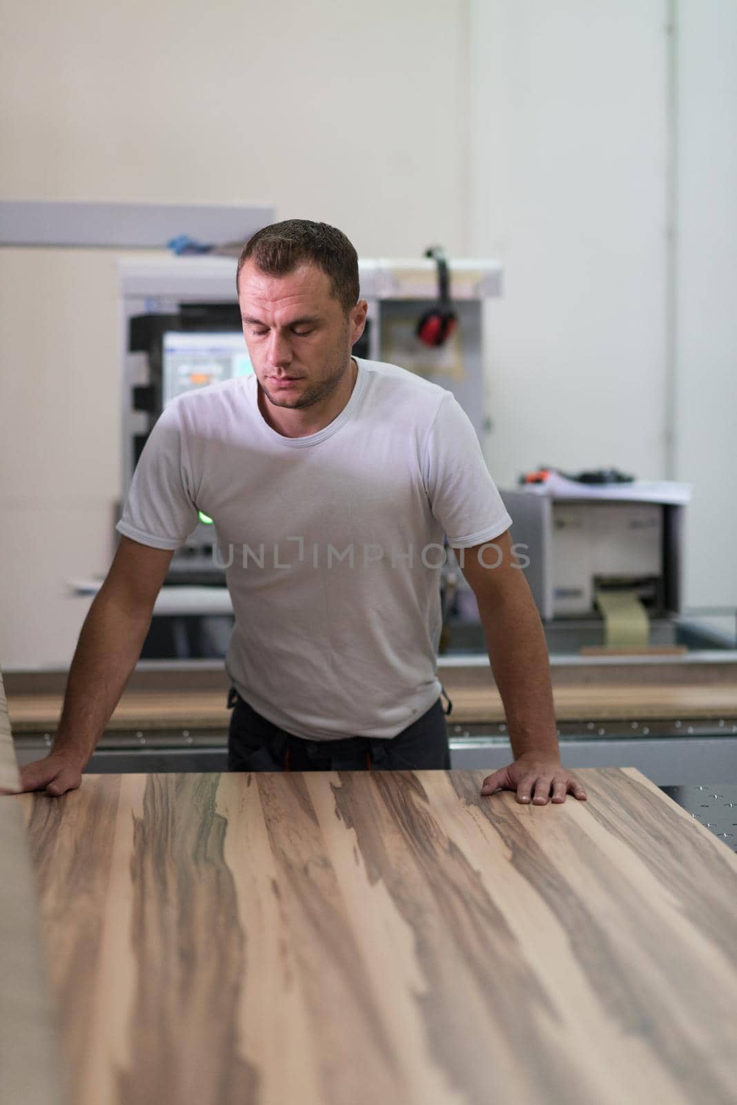 Young worker works in a factory for the production of wooden furniture