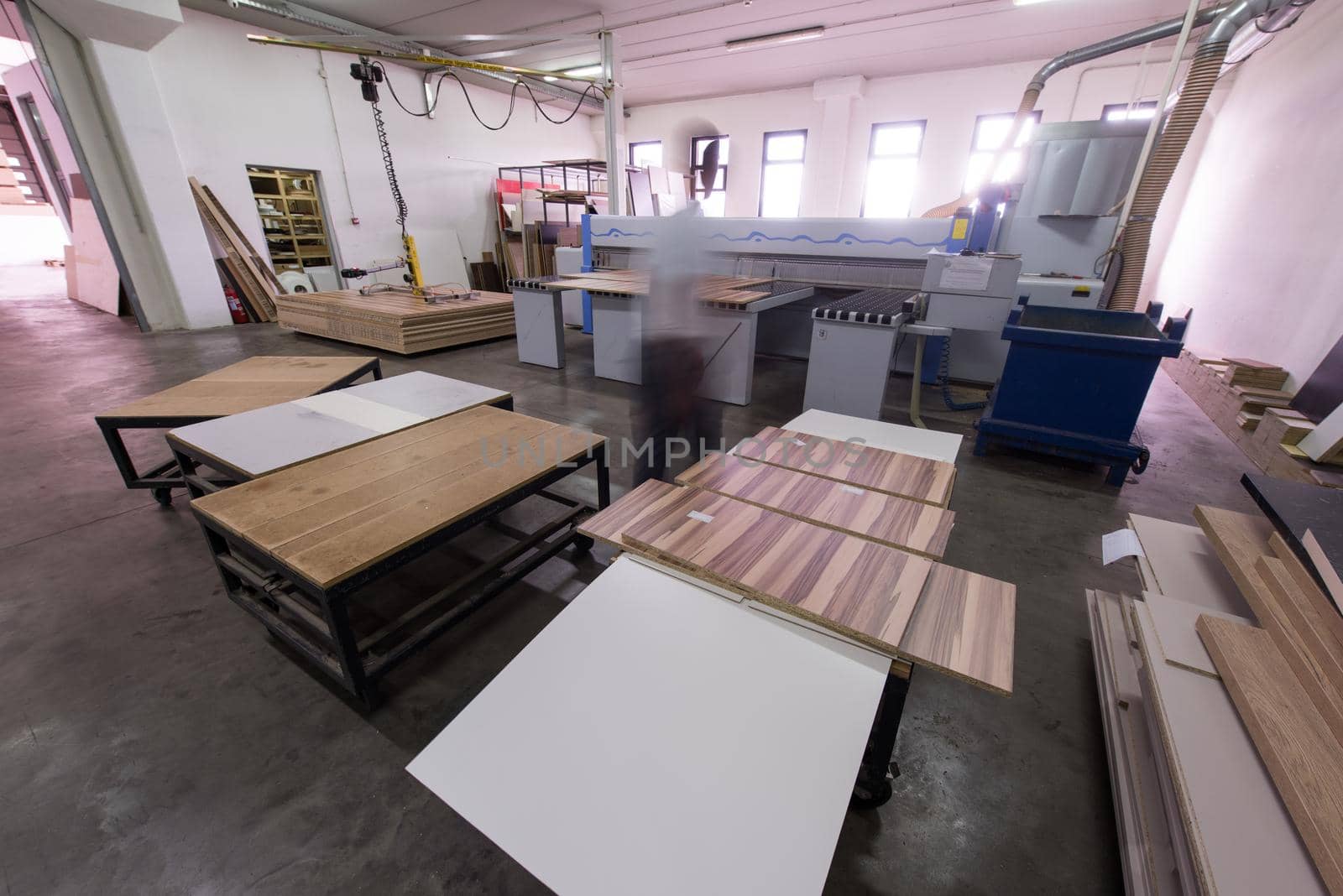 Young worker works in a factory for the production of wooden furniture