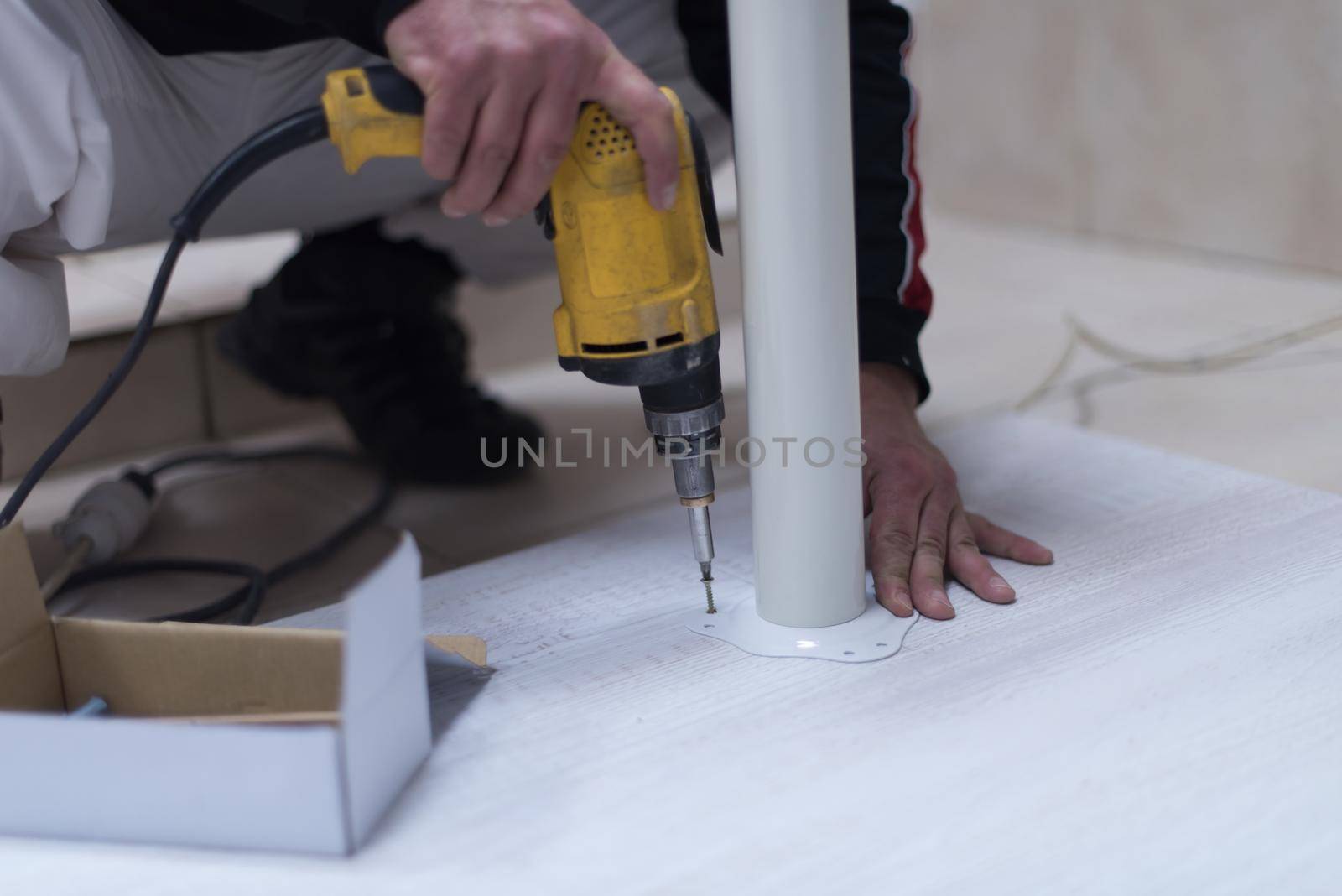 repairman working with drilling machine and assambling  furniture