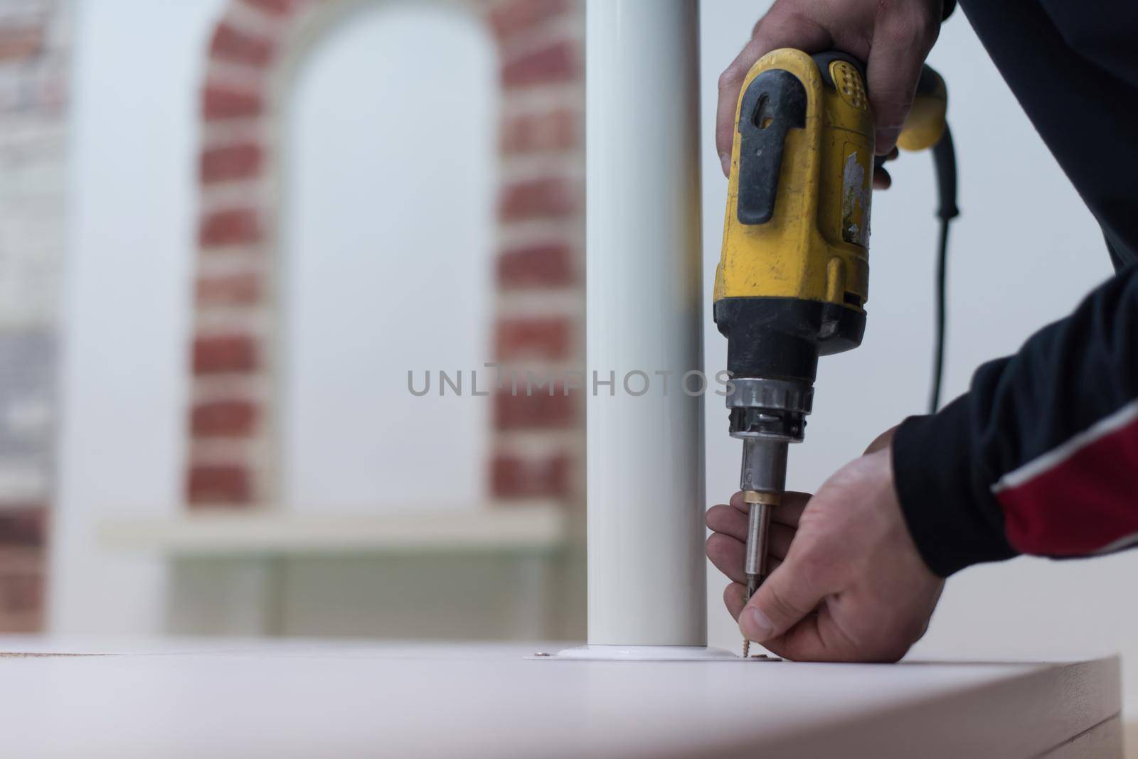 repairman working with drilling machine and assambling  furniture