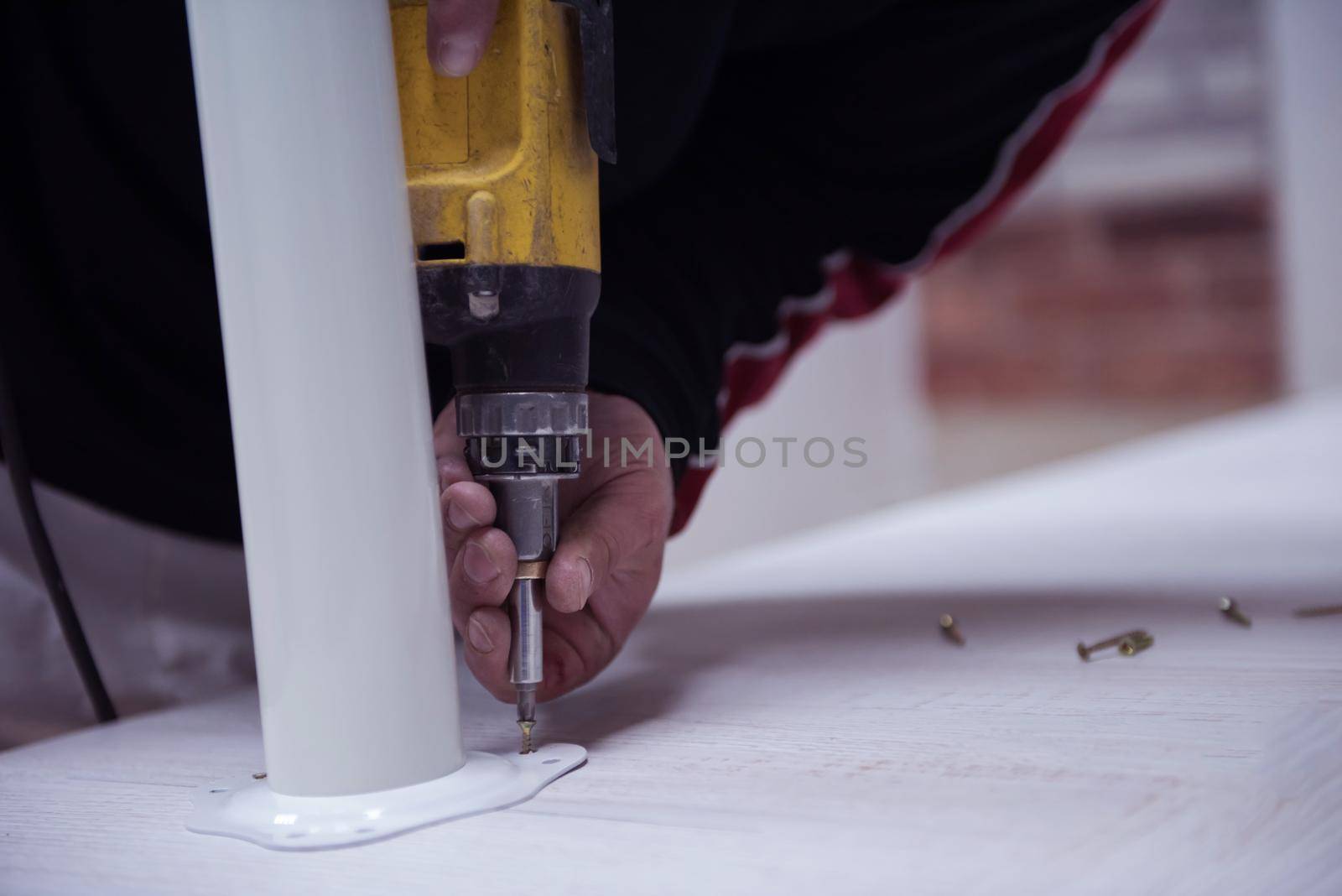 repairman working with drilling machine and assambling  furniture