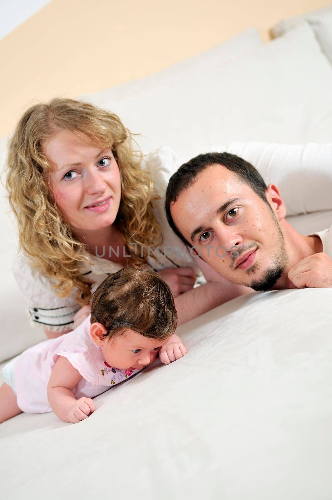 indoor portrait with happy young family and  cute little babby 