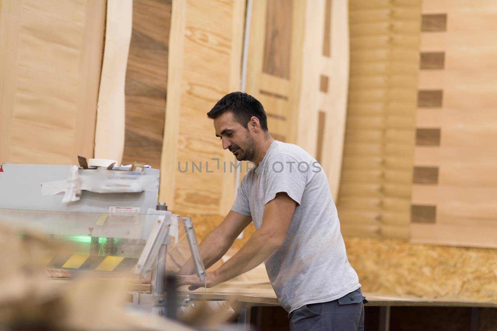 Young worker works in a factory for the production of wooden furniture