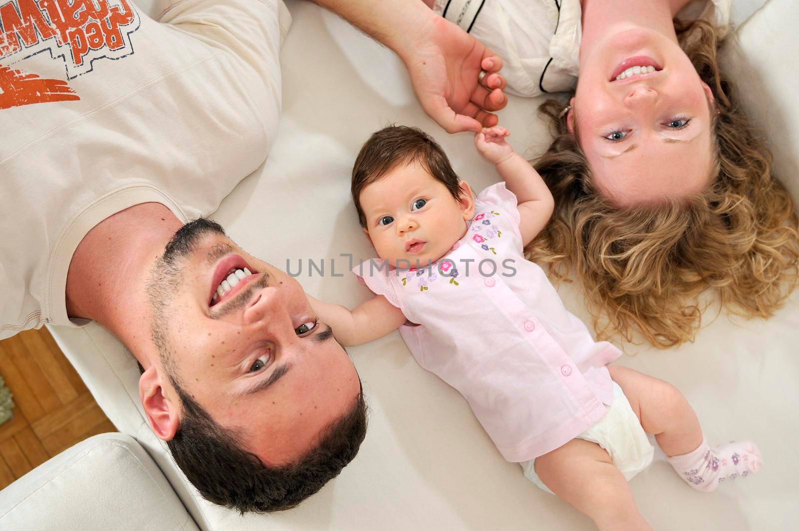 indoor portrait with happy young family and  cute little babby  by dotshock