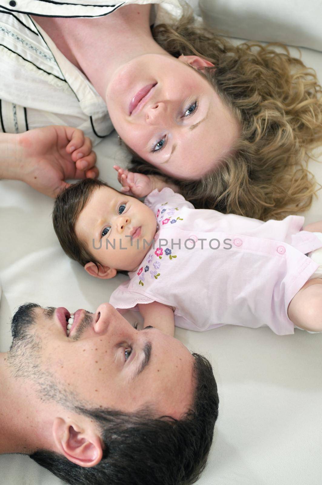 indoor portrait with happy young family and  cute little babby