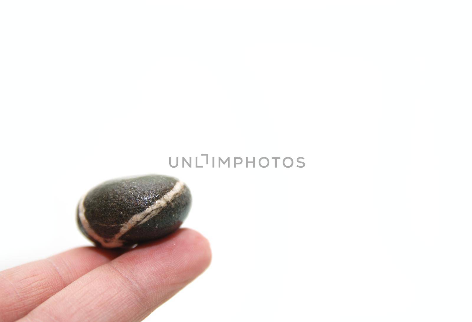 .zen stone on finger representing balance concept by dotshock