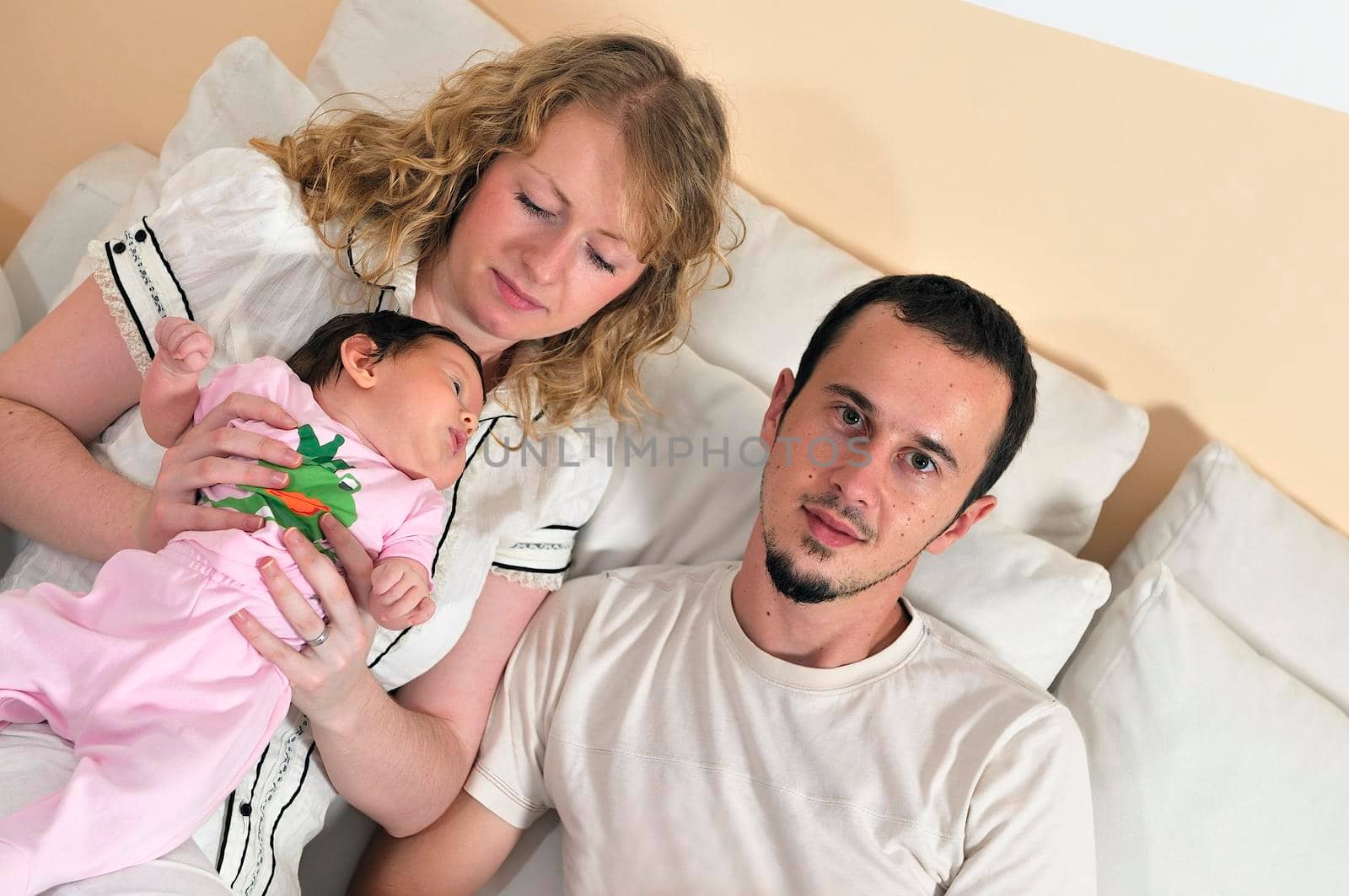 indoor portrait with happy young family and  cute little babby