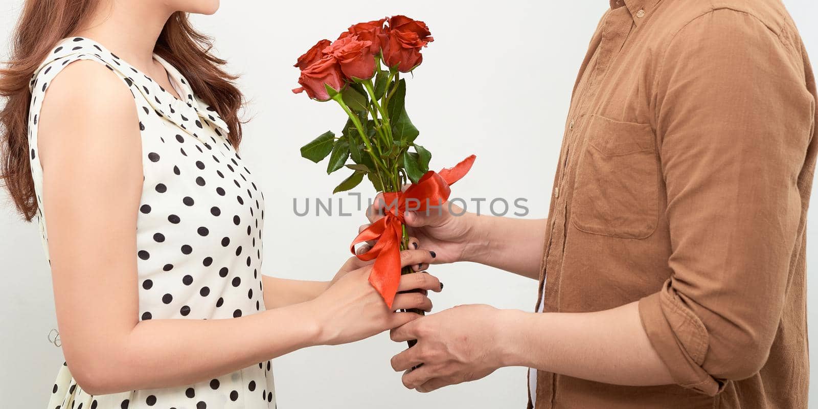 Young beautiful asian couple with flowers isolated on white