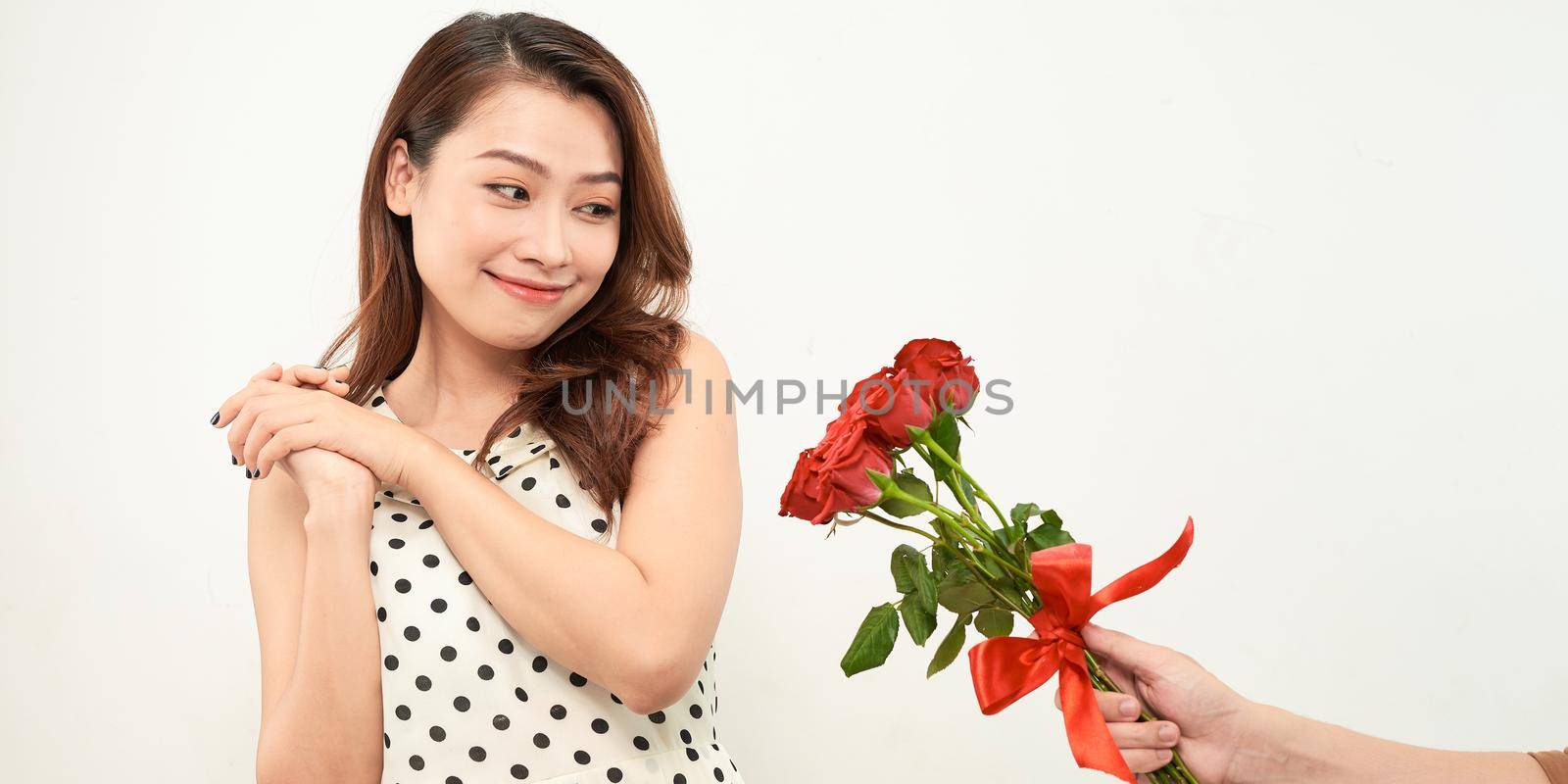 boyfriend presenting bouquet of roses to girlfriend isolated on white