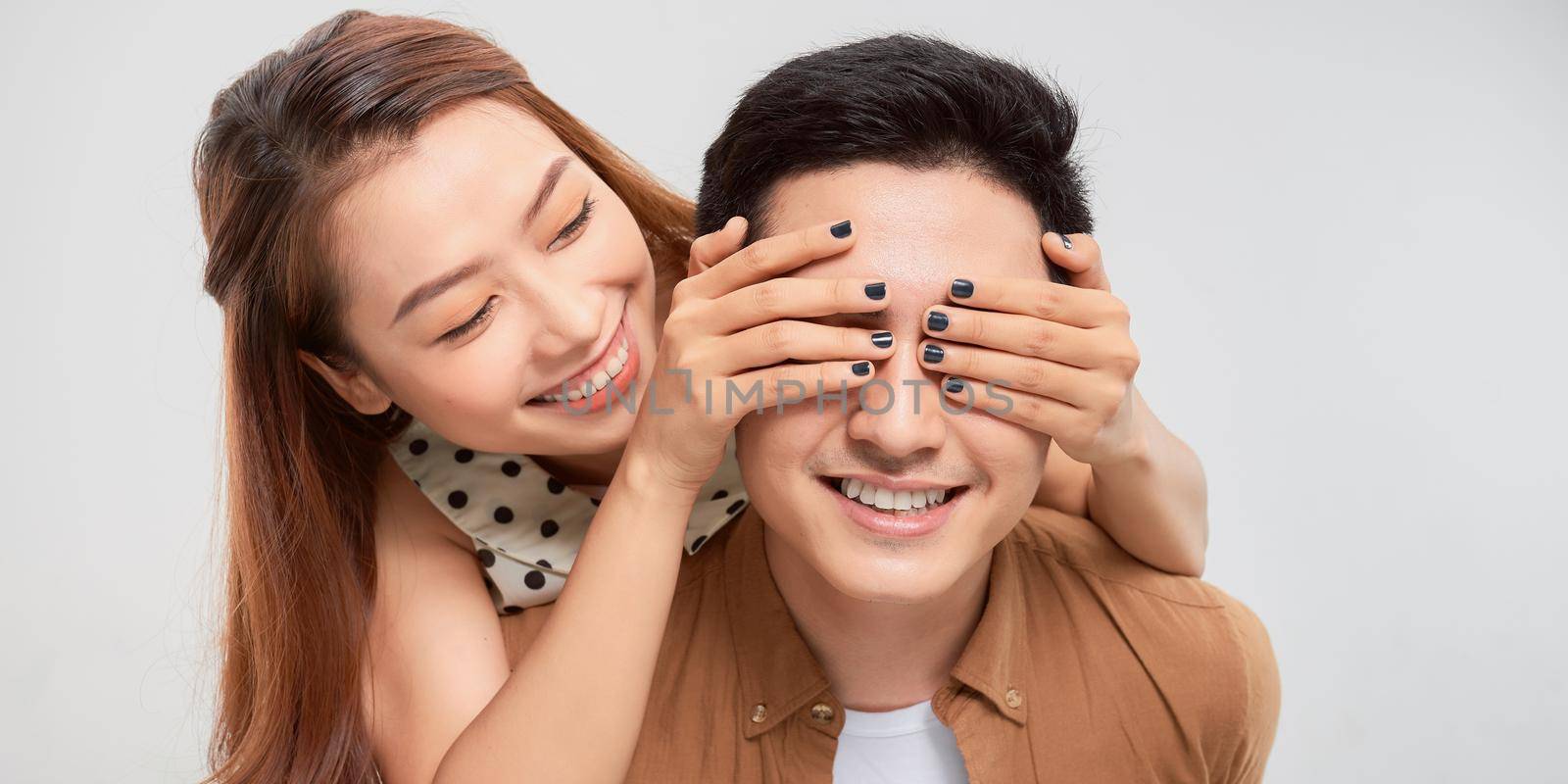 Man giving his pretty girlfriend a piggy back on white background