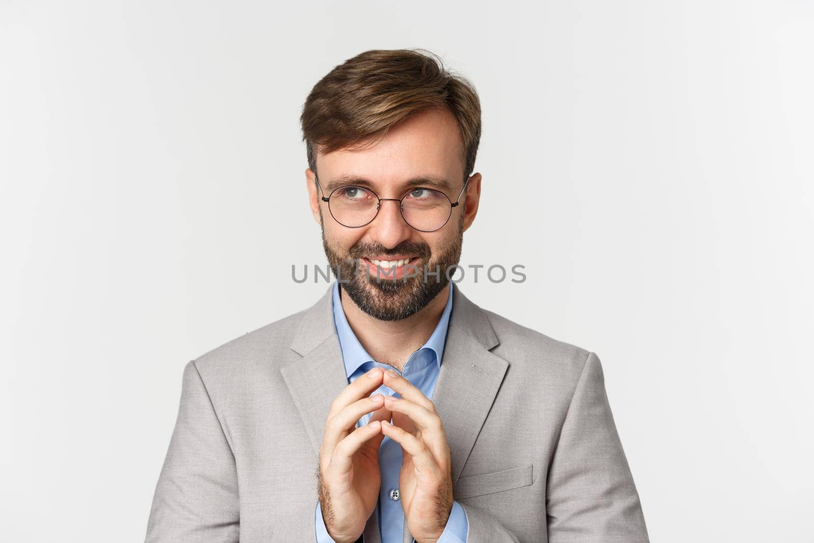 Close-up of thoughtful and devious businessman having an idea, smiling cunning and looking at upper left corner, steeple finers and scheming something, white background by Benzoix