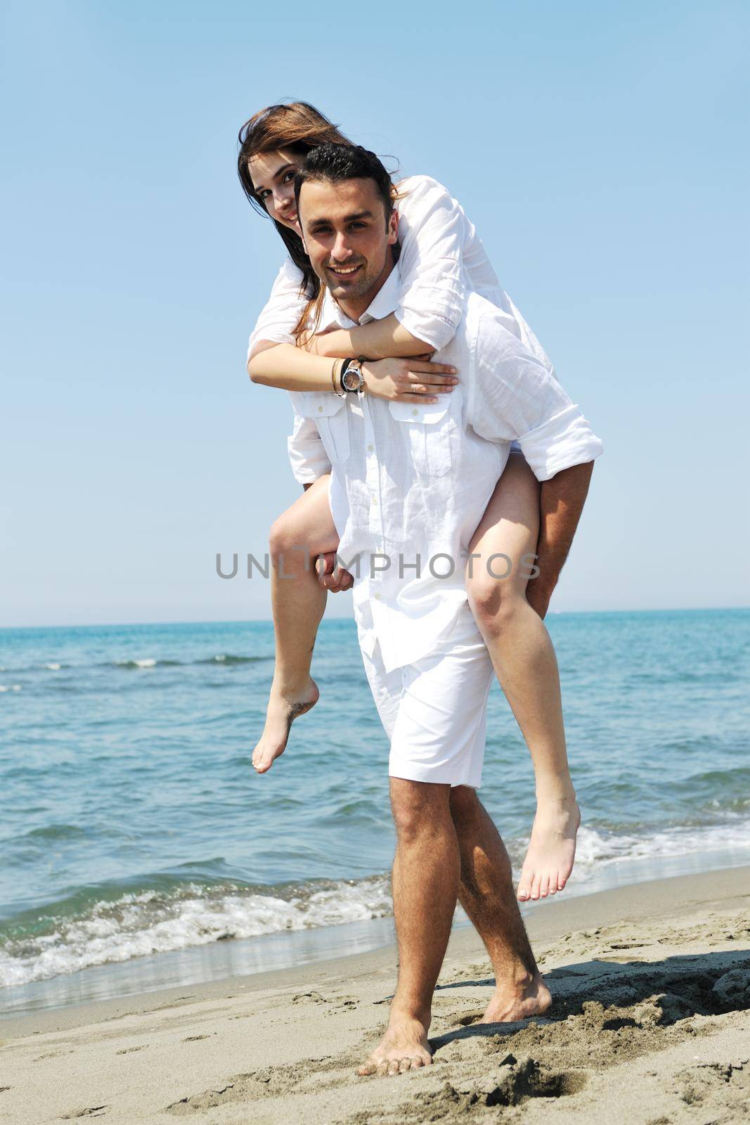 happy young couple have fun and romantic moments on beach at summer season and representing happynes and travel concept