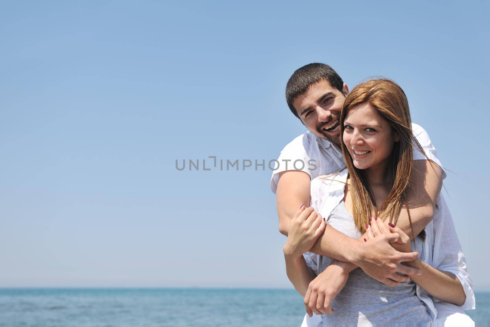 happy young couple have fun and romantic moments on beach at summer season and representing happynes and travel concept