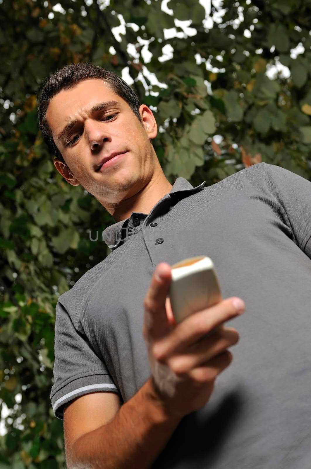 young happy  casual man talking on cellphone and writing sms message