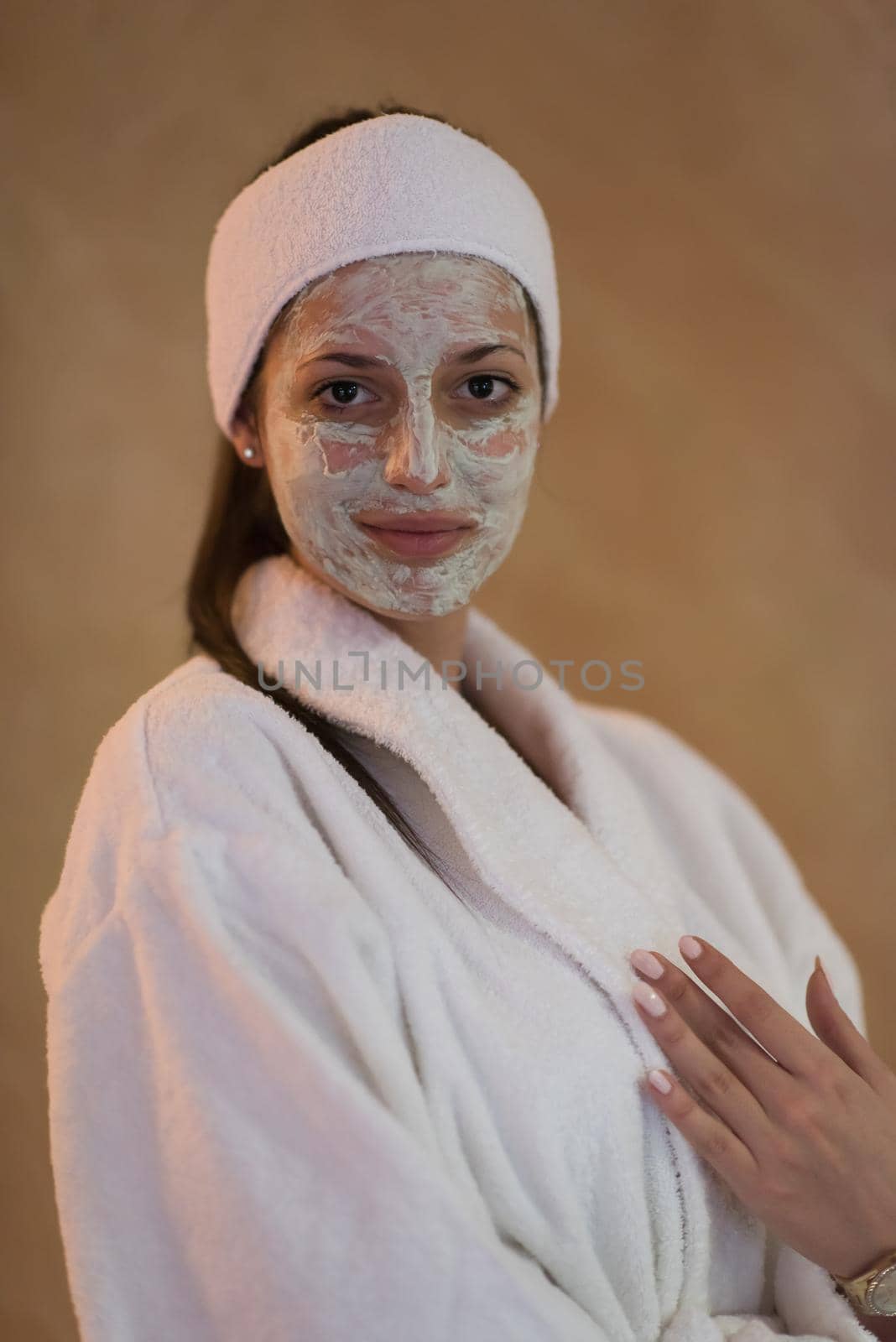 Spa Woman applying Facial Mask  Beauty Treatments  Close up portrait of beautiful girl with a towel on her head applying facial mask