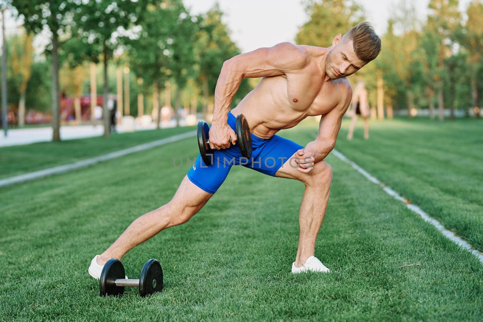sporty man with pumped up body in park workout exercise. High quality photo