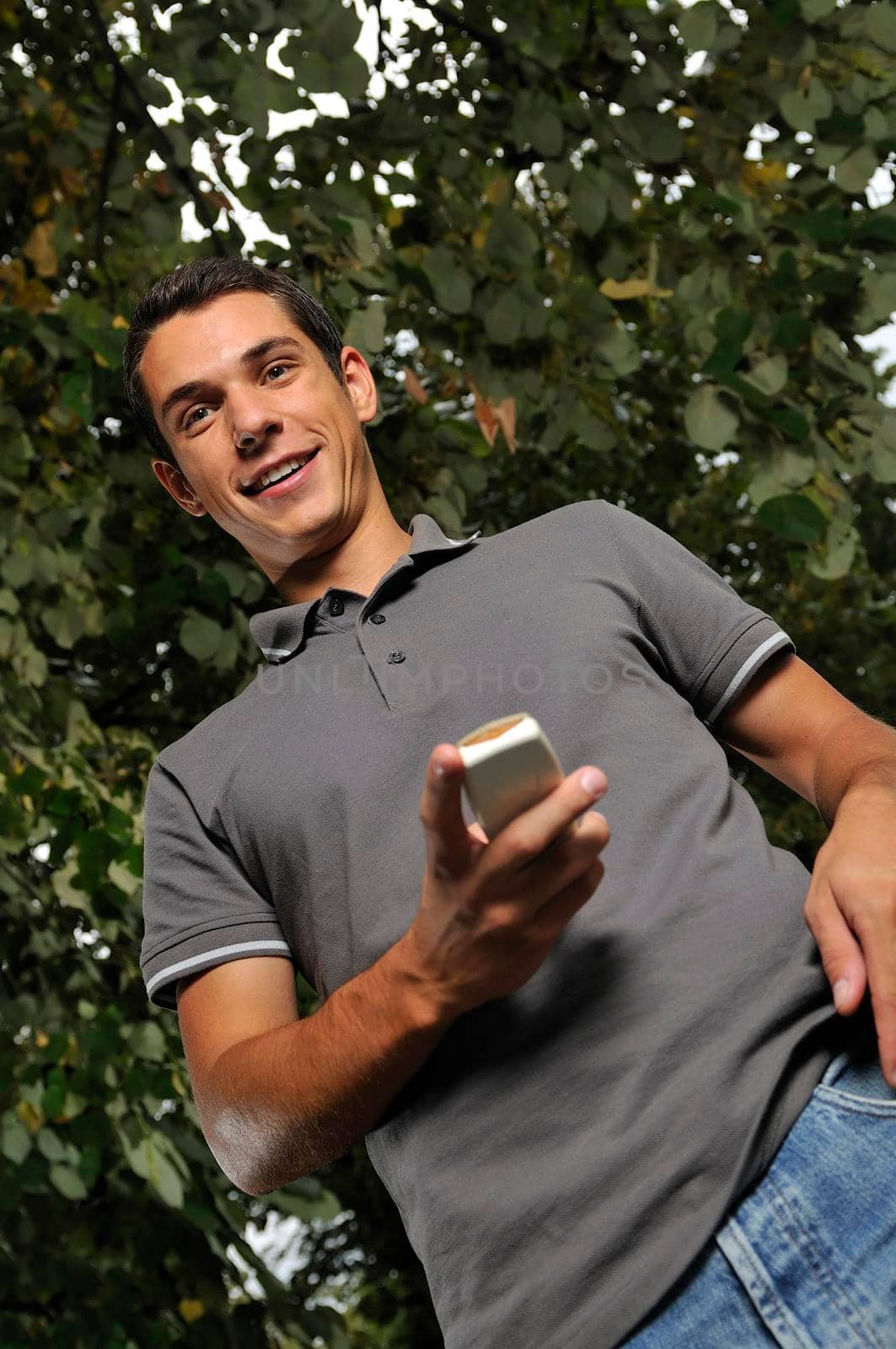 young happy  casual man talking on cellphone and writing sms message