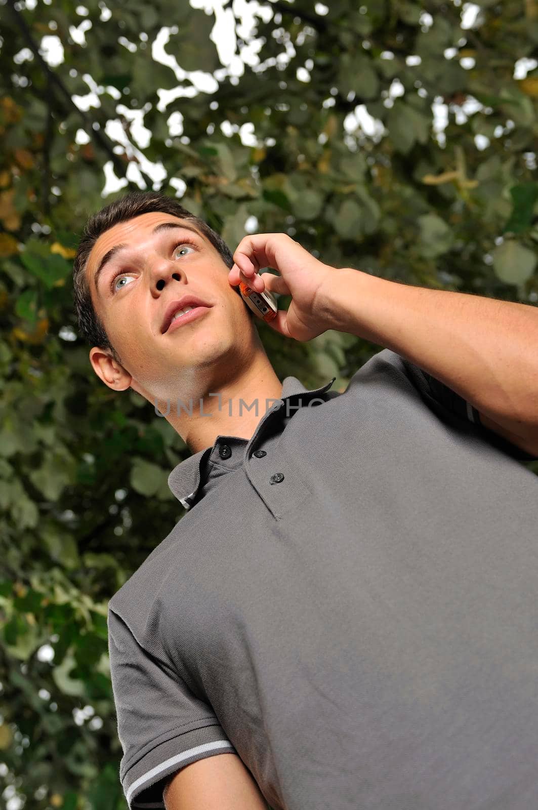 young happy  casual man talking on cellphone and writing sms message