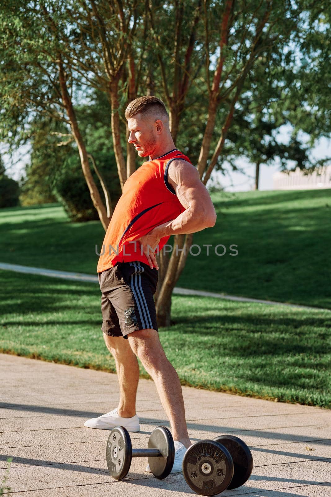 sporty man in the morning in the park with dumbbells exercise. High quality photo