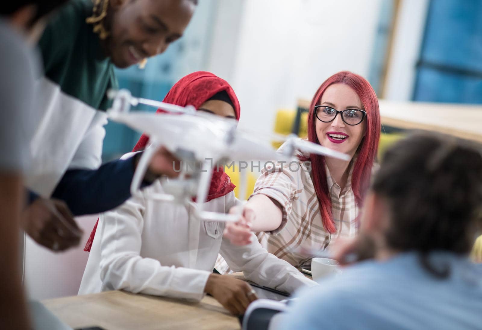 multiethnic startup business team discussing new business plan,working on laptop and tablet computer while learning about drone technology for new business advancement