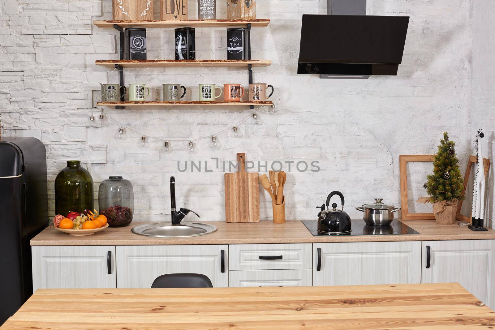 Empty wooden table, sink and stove in kitchen interior. Copy space