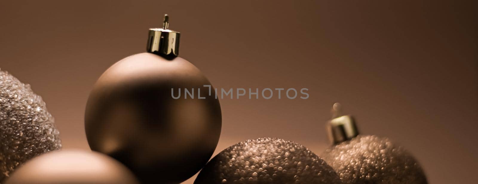 Christmas holiday and festive decoration concept. Golden baubles on beige background.