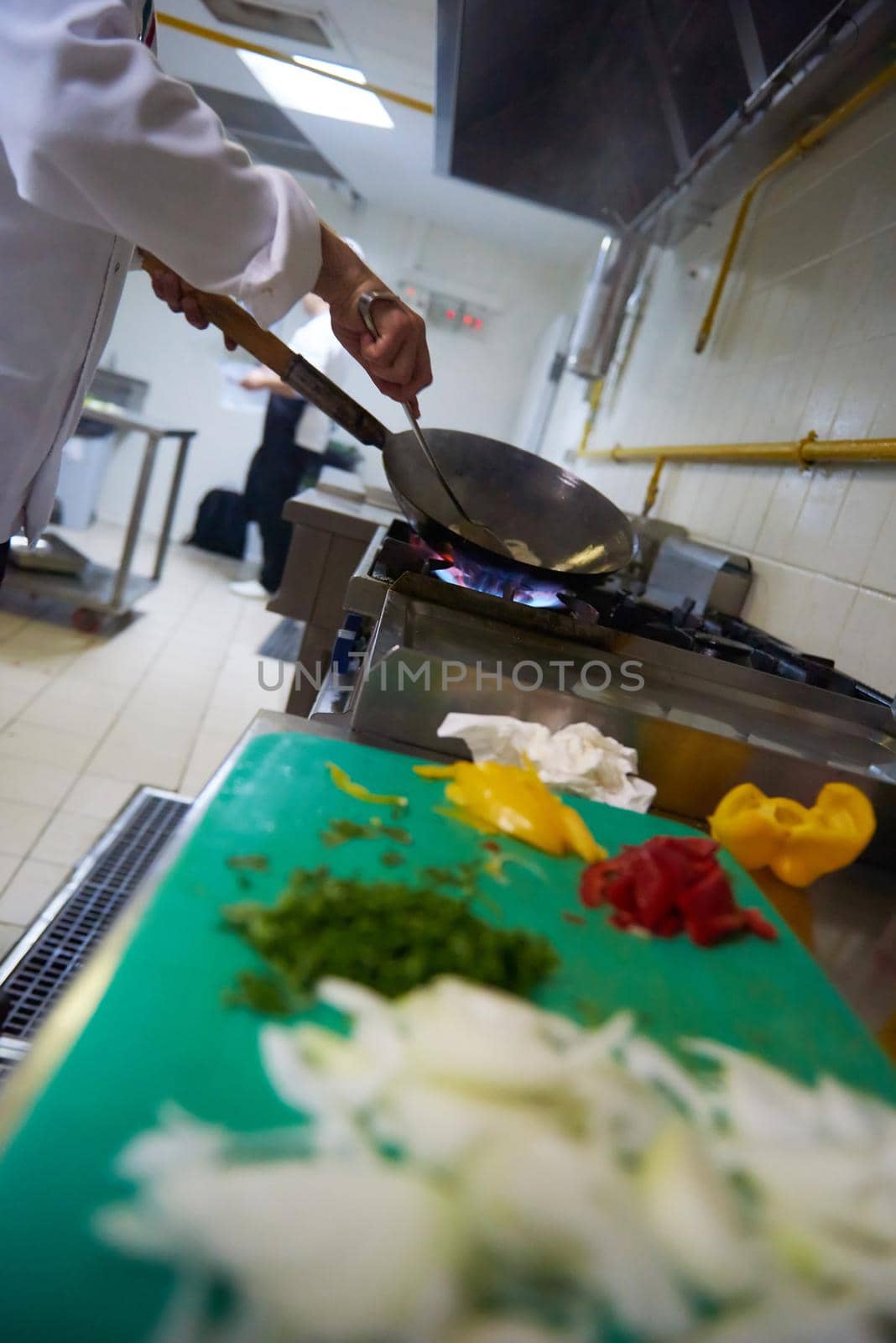 chef in hotel kitchen prepare food with fire by dotshock
