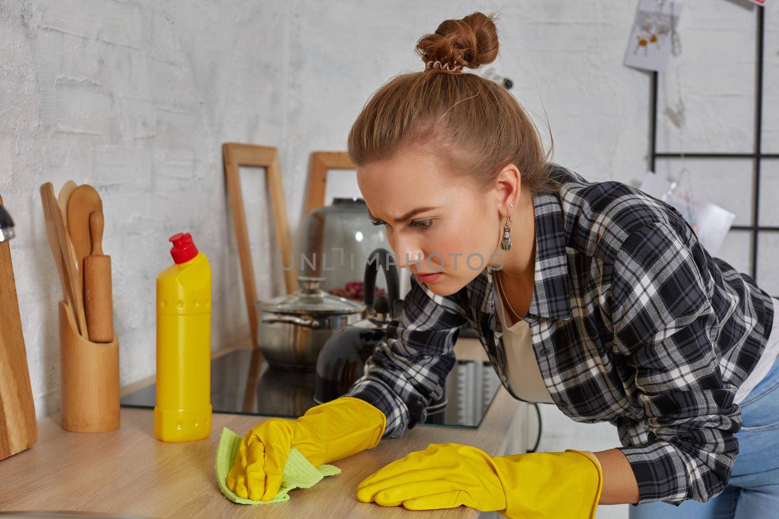 Hand cleaning. Young housewife woman washing sink in kitchen. Young woman washing manually, by hand, wearing yellow cleaning rubber gloves.