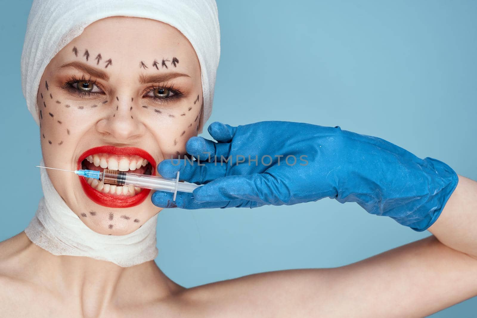 portrait of a woman in blue gloves syringe in hands contour on the face lifting isolated background. High quality photo
