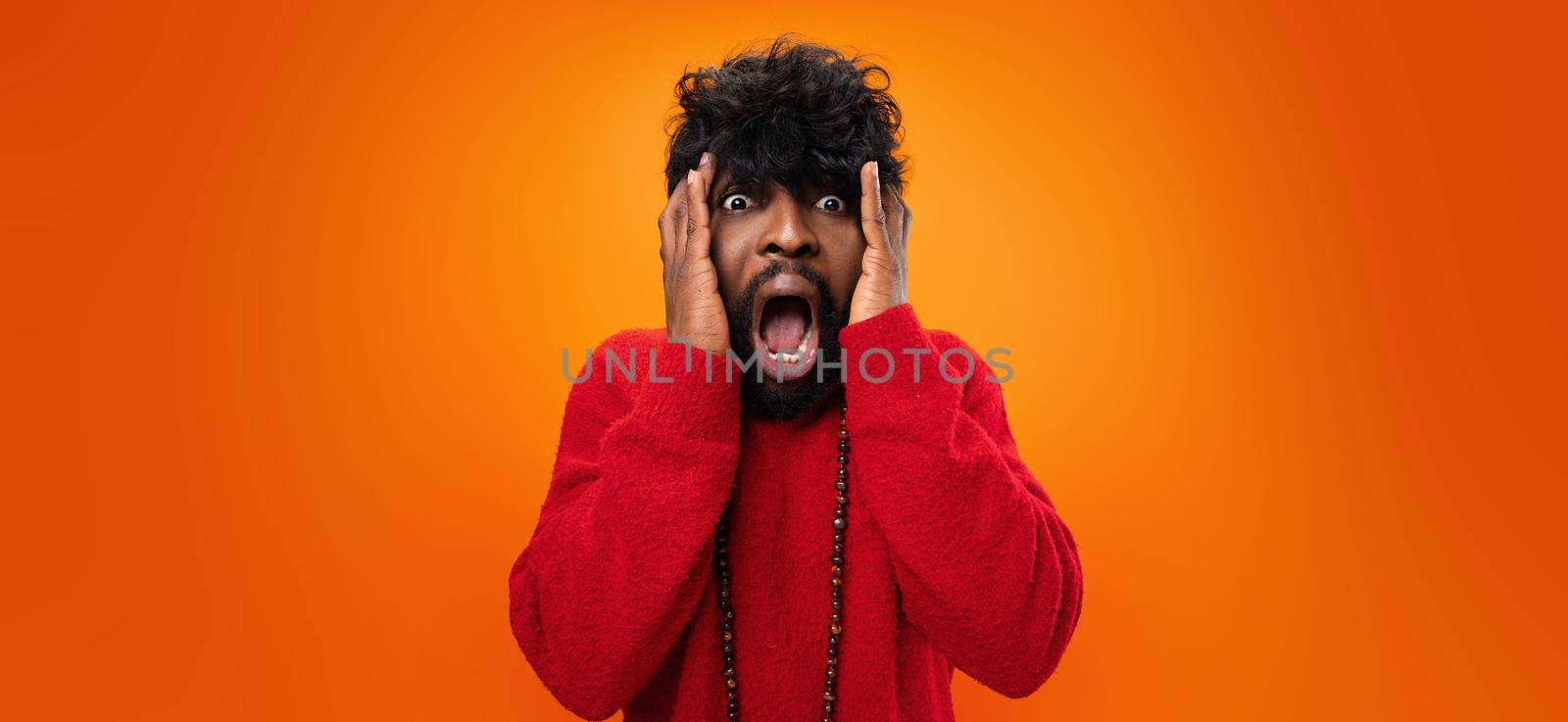 Young thrilled casual black man screaming on yellow background by Fabrikasimf