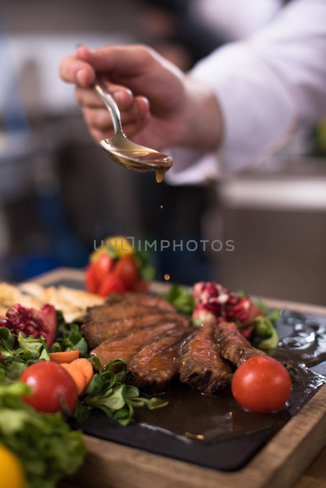 Chef hand finishing steak meat plate by dotshock