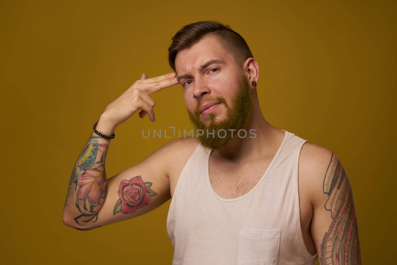 macho man in white t-shirt tattoos on his arms posing isolated background. High quality photo