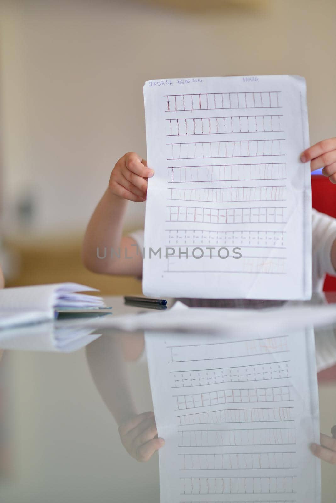 young mom woman doing home work with elementary school grade boy at home in kitchen