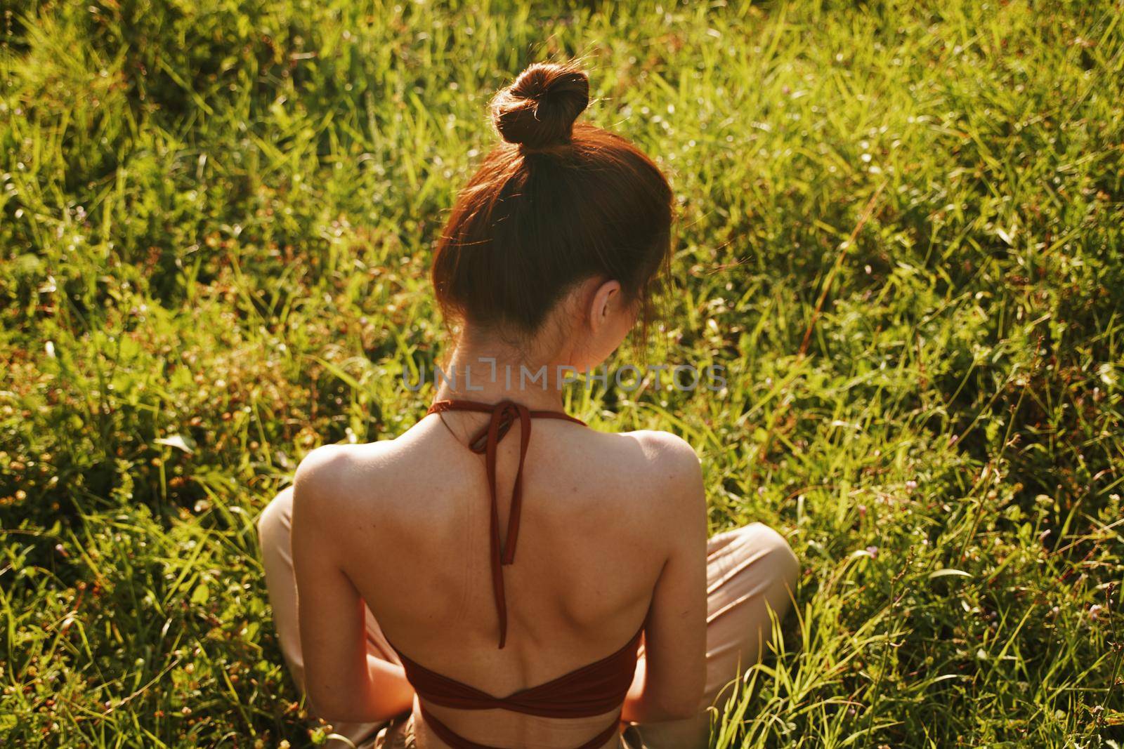 woman in the field sitting on the grass meditation rest. High quality photo