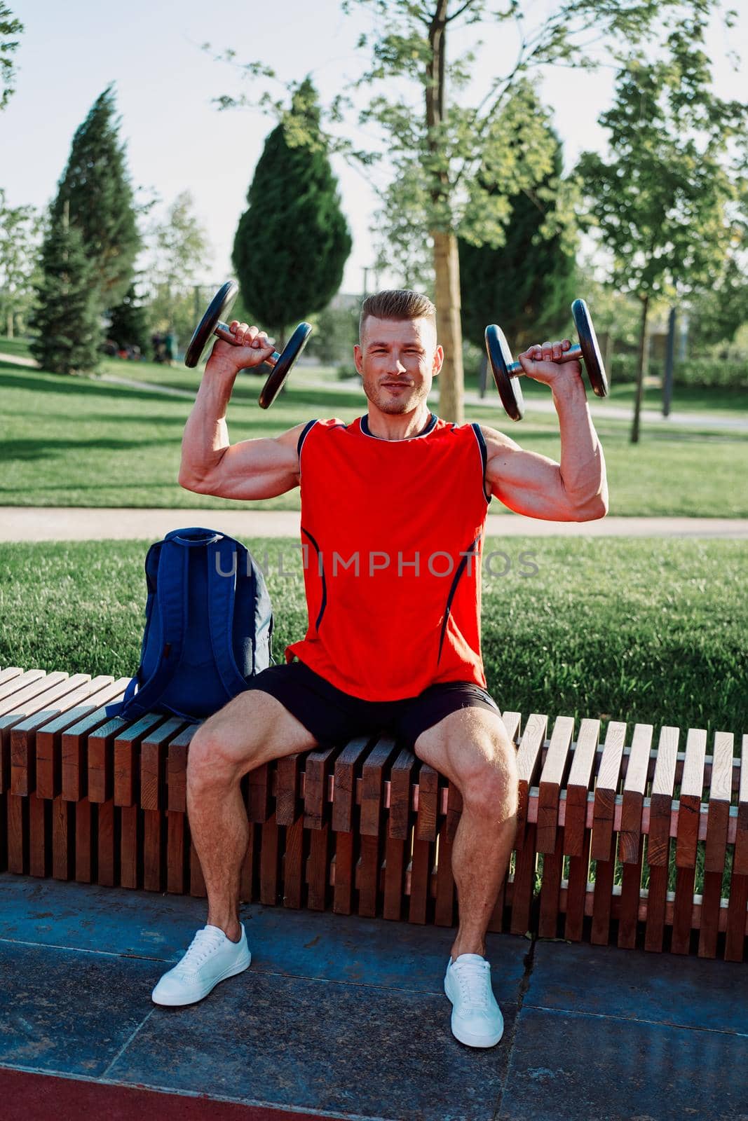 athletic man in red t-shirt in fitness park. High quality photo