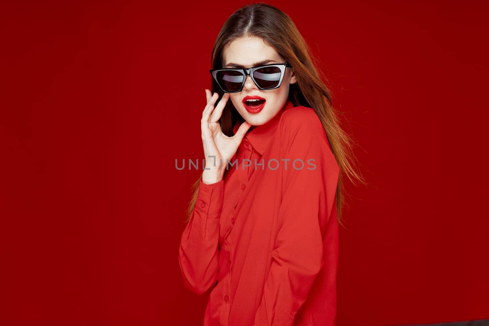 glamorous woman wearing sunglasses red shirt hairstyle model. High quality photo