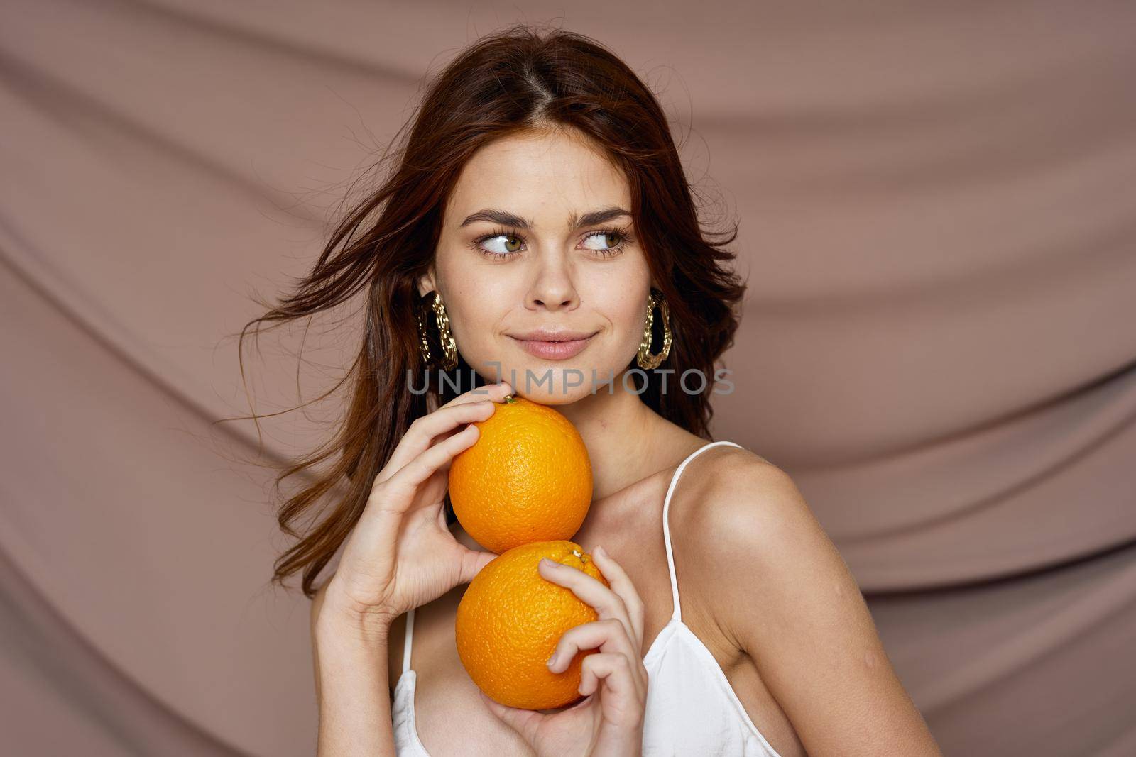 pretty woman with oranges in hands studio. High quality photo